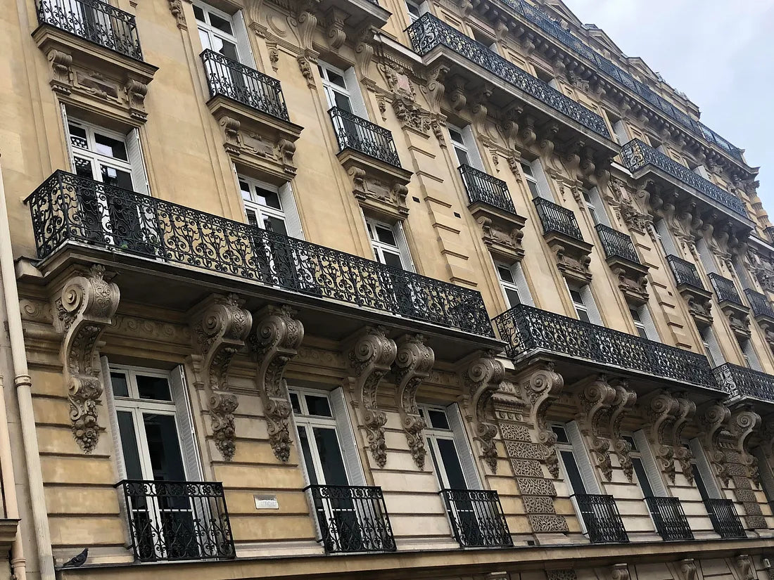 Elegant building facade featuring intricate corbels and ornate balconies