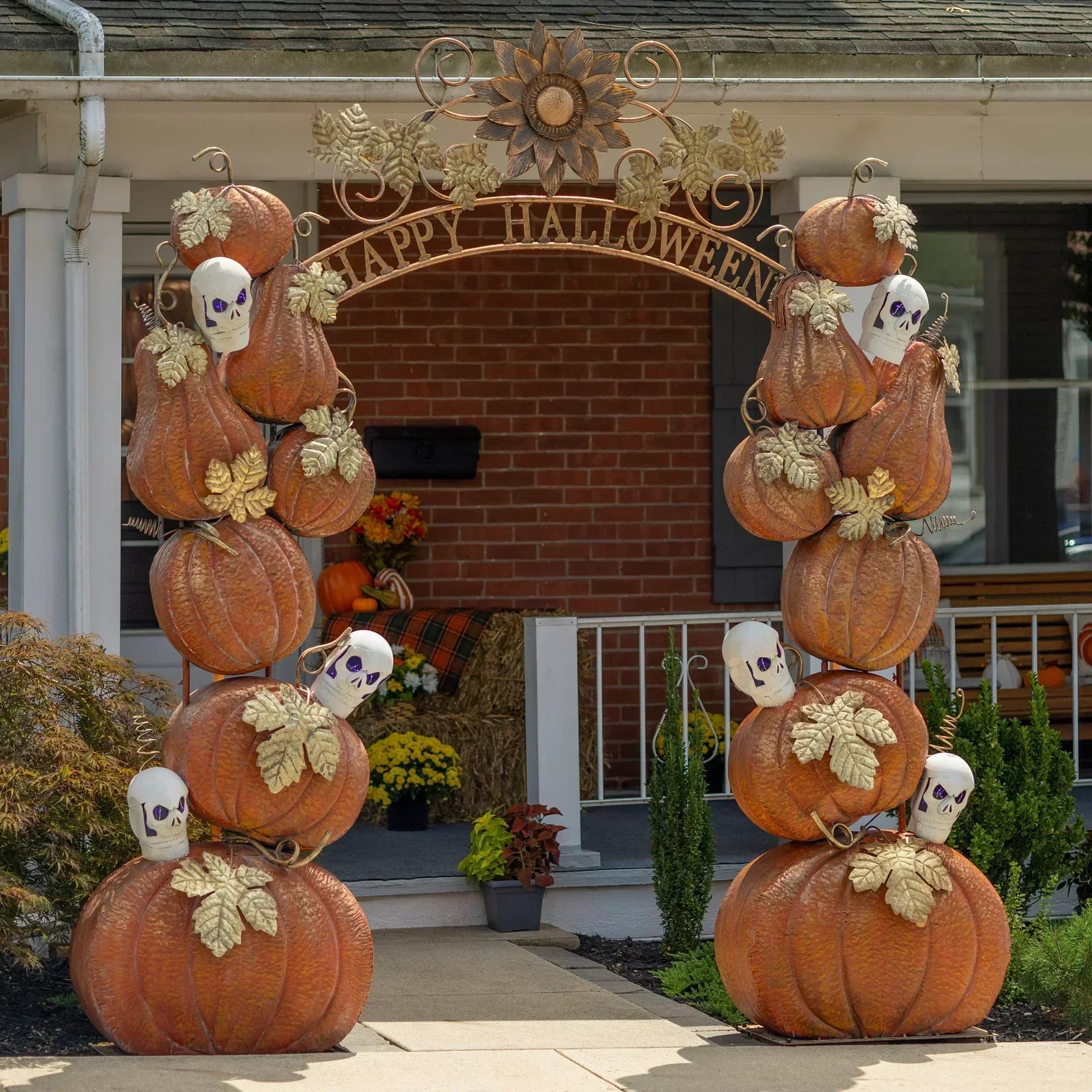 Festive Halloween archway adorned with pumpkins, skulls, and autumn leaves