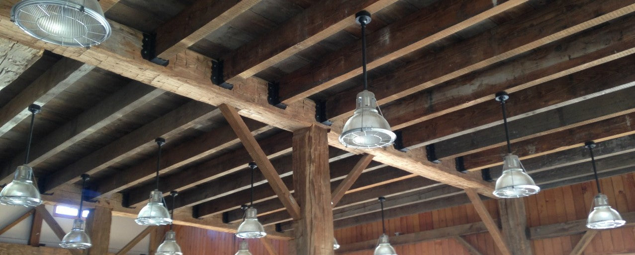 Rustic wooden beams with decorative joist hangers and hanging industrial lights