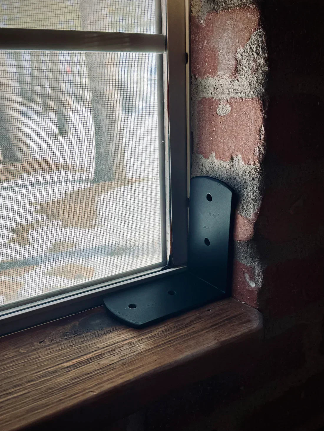 black metal corner strap installed at a window for DIY home improvement projects