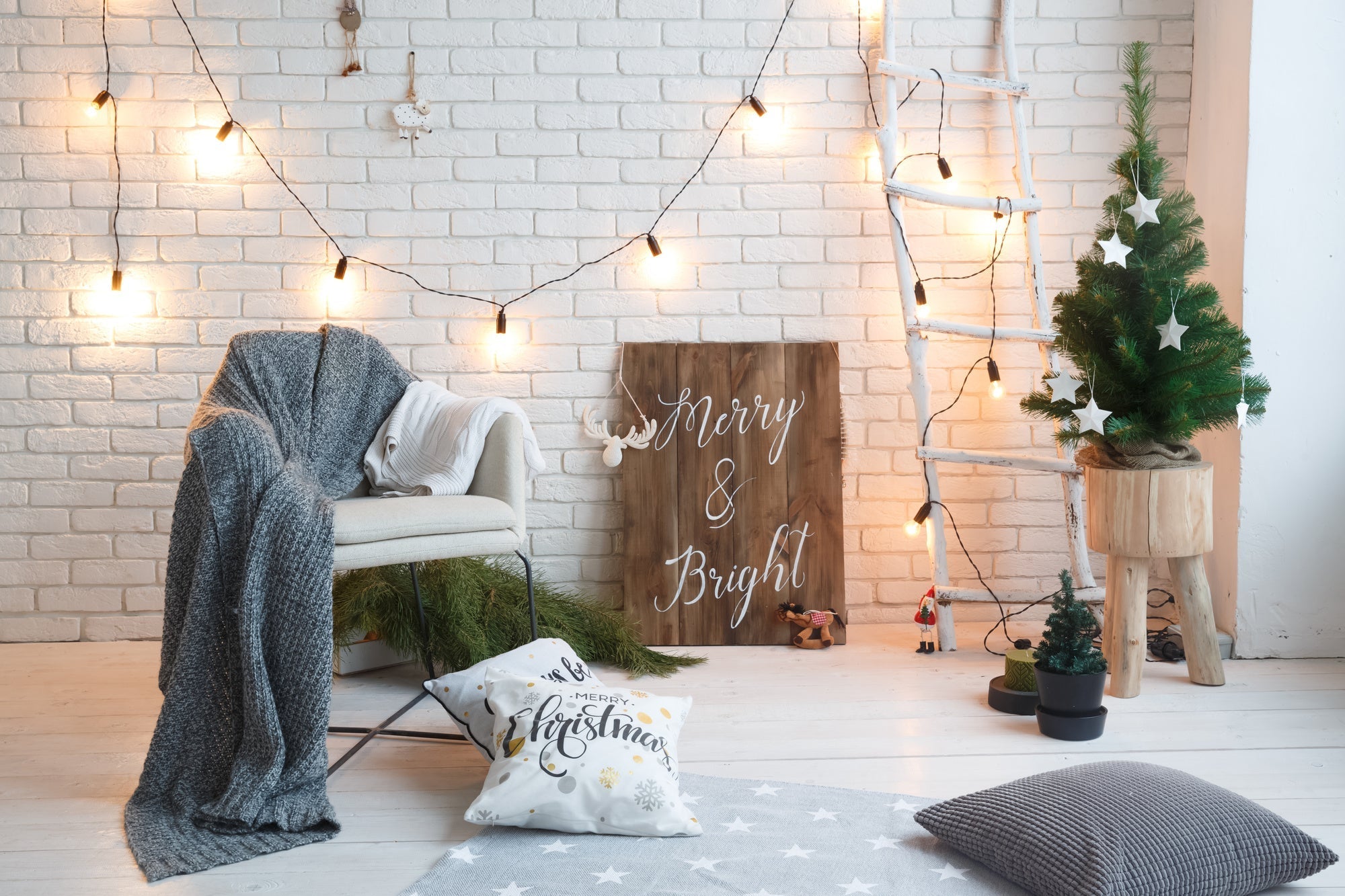 Cozy winter home decor with string lights, festive pillows, and a Christmas tree