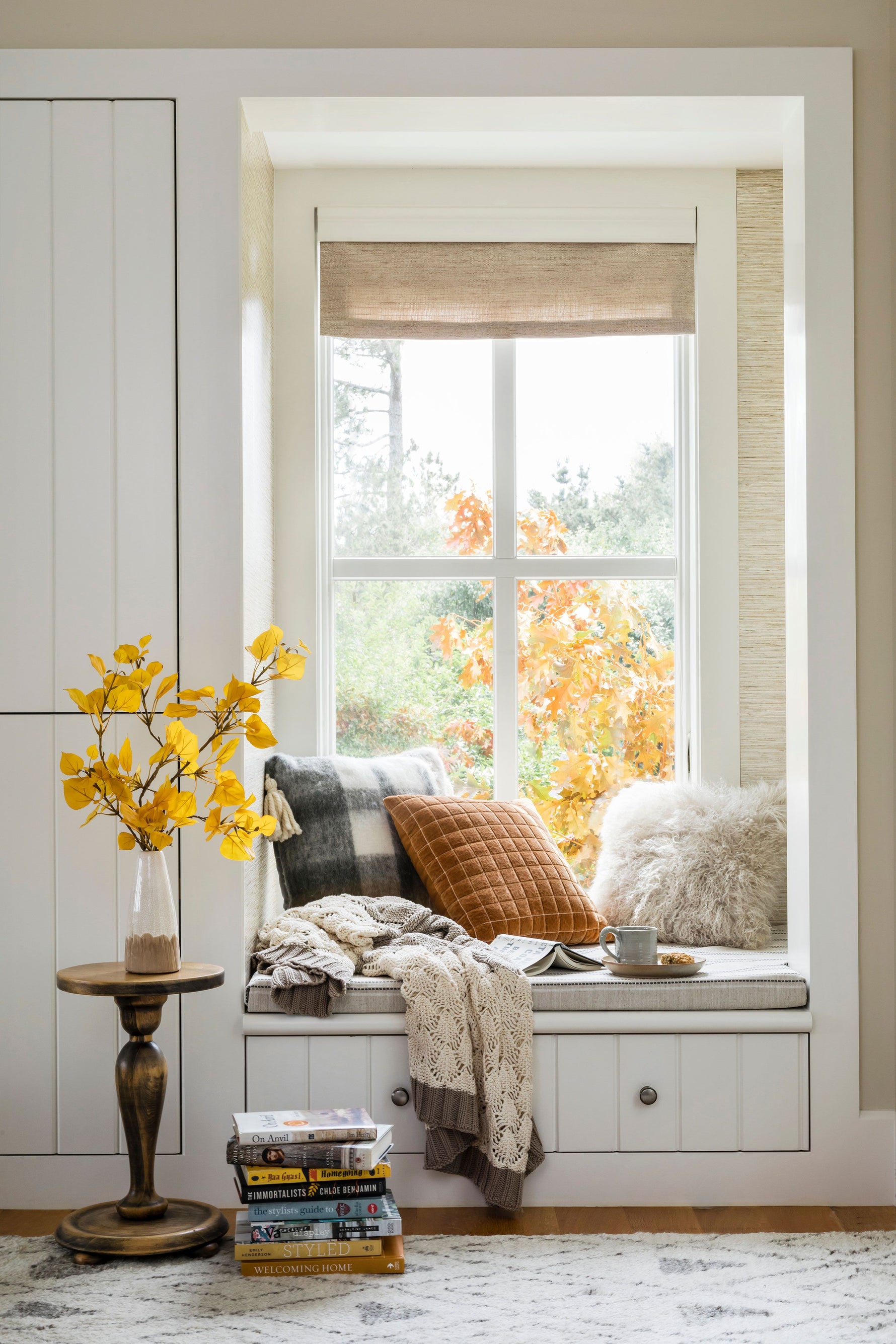 Cozy window seat adorned with cushions and flowers, perfect for reading and enjoying nature