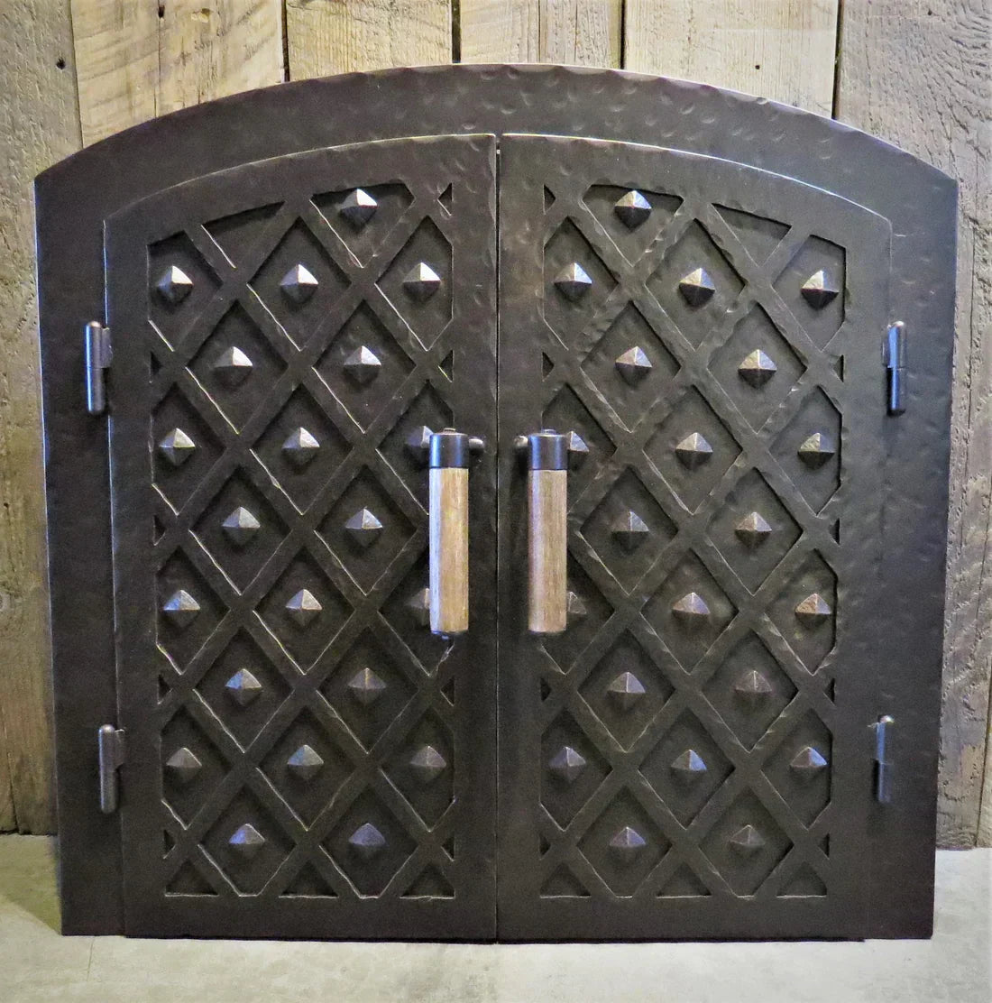 Decorative handmade pizza oven door with diamond pattern and sturdy handles from Old West Iron