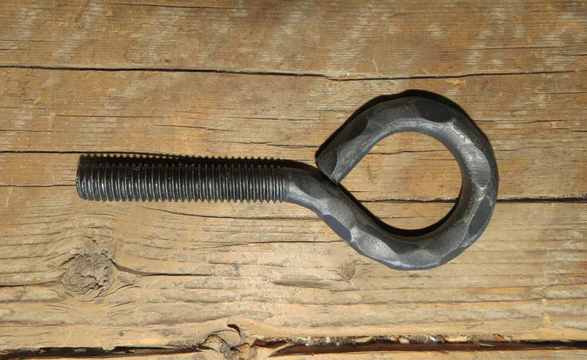 close-up of a heavy-duty eye bolt on rustic wooden surface suitable for construction projects