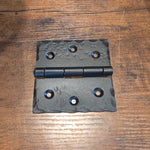 Black metal hinge on a wooden surface