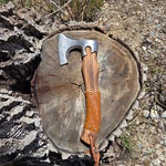 Axes with leather handles on a tree stump outdoors