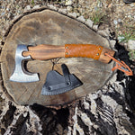 Axes with leather sheaths on a wooden stump outdoors