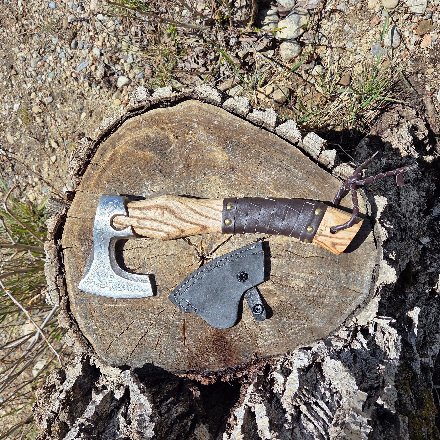 Wooden block with hand holding axes on a natural background