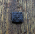 A black distressed textured square head lag in a piece of wood for the background