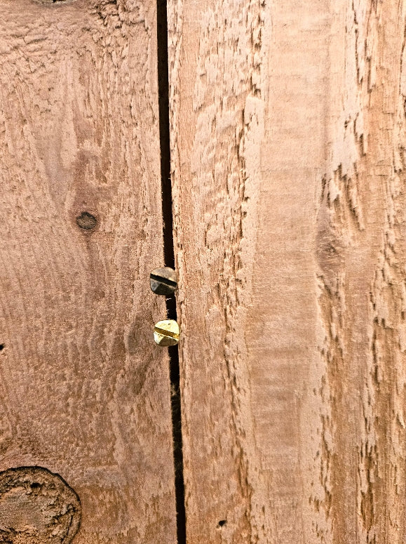 brass pyramid round wood screws on a wooden surface