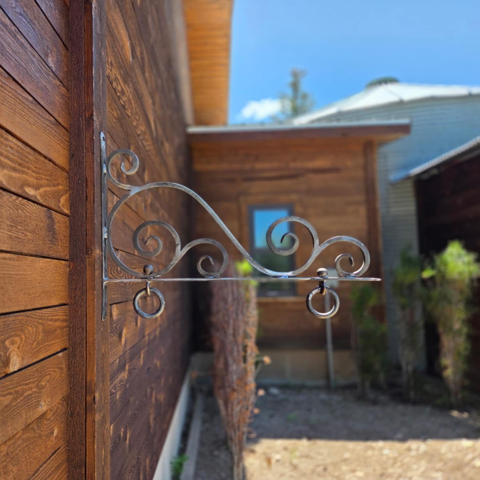 Decorative metal bracket on a wooden wall with a blurred background