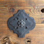 Decorative metal bracket on a wooden surface