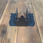Black metal joist tie bracket on a wooden wall