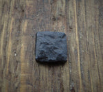 A black distressed textured square head lag in a piece of wood for the background