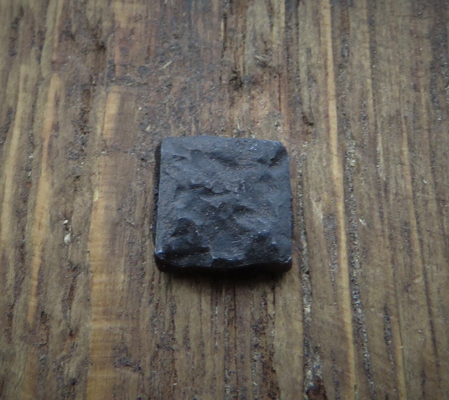 A black distressed textured square head lag in a piece of wood for the background