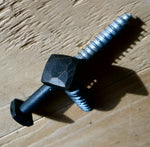 a top and side view of a 5/8" hand hammered square head lag that is painted black with an oil rubbed bronze finish on a wood background