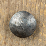 A top view of a carriage bolt that has a smooth texture and a raw metal finish.