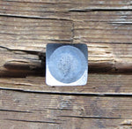 A square head bolt with a smooth texture with a raw finish installed on a wood background.