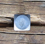 A square head bolt that has a smooth texture and is left with a raw metal finish  installed on a wood background.