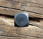 A Square head bolt with a smooth texture painted back with an oil rubbed bronze patina as the finish installed on a wood background.