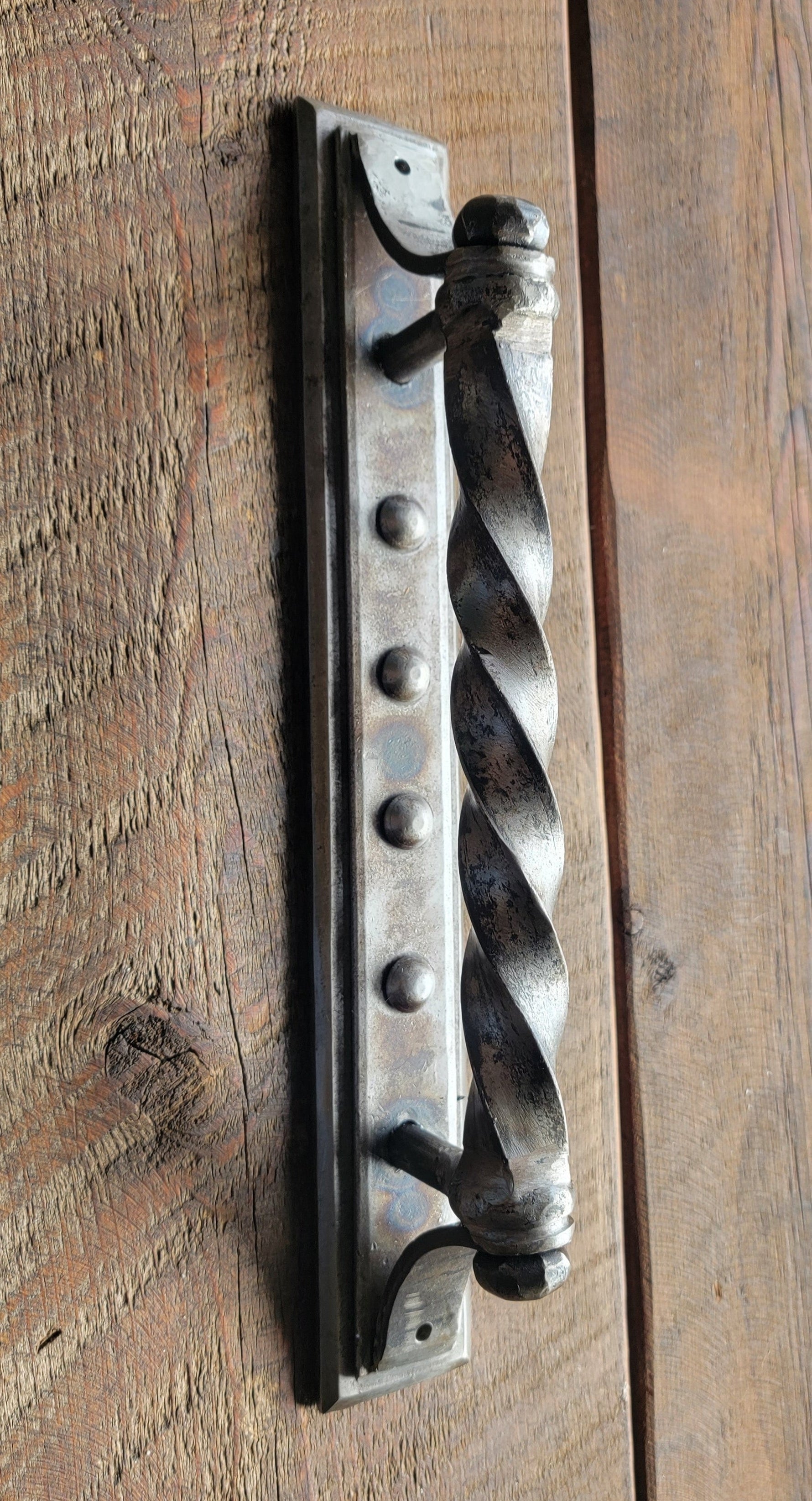 Decorative metal door handle on a wooden door